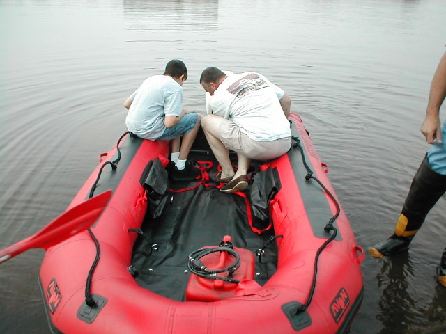 FF Bobby Cole helps Chief Morgan mount the motor.